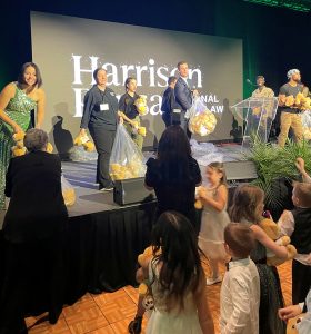 Harrison Pensa personal injury lawyer Andy Rady and staff toss teddy bears to a crowd of children attending the Magical Winter Ball.
